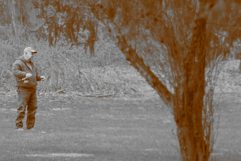 sepia vintage looking effect on man casting fishing line into grass