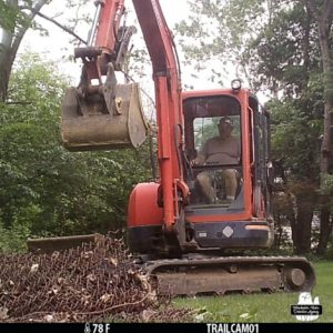 trail camera image of The Grumpy Old Man in backhoe machine