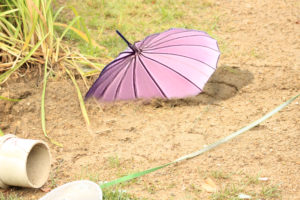 pink parasol "sinking" into dirt "quicksand"