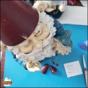garden gnome, Gnomez Addams, on the desk for with his hat broken for first repair attempt with super glue