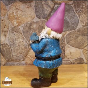 2025 side view of garden gnome, Gnomez Addams on kitchen wooden board after baking. The hat clay was purple and needed to be repainted red.