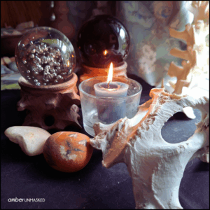 Mabon / Autumn Equinox witch altar (candle burning, stones, crystal balls on holders, the cleaning pelvic bone of a deer, hanging cleaned spine of a deer